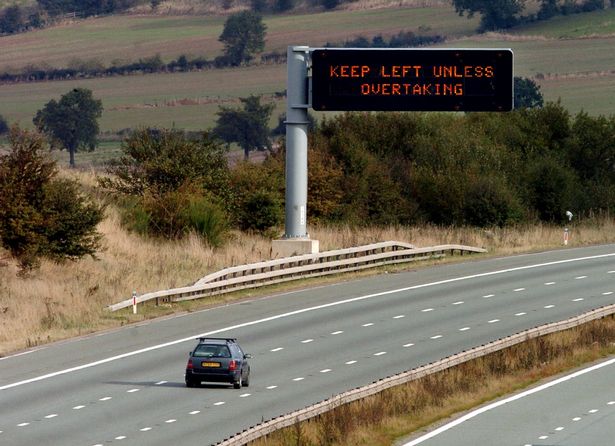 Image of a car driving in the middle lane of an empty motorway